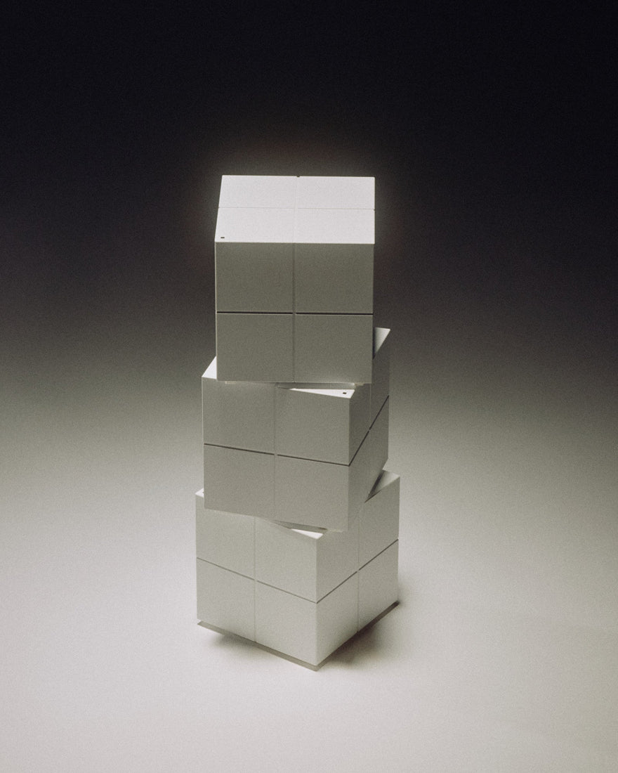 Stack of three silver blocks on a grey-black gradient background